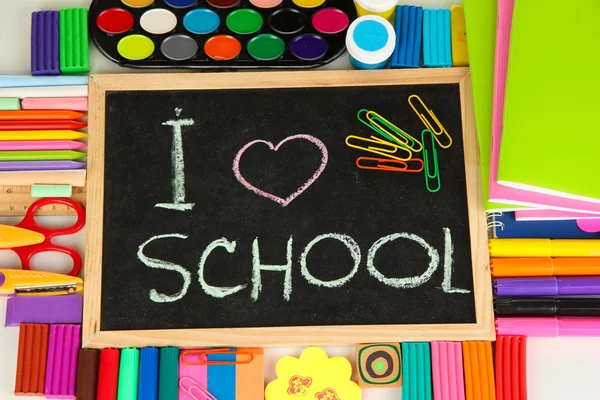 Pequeño escritorio escolar con varios útiles escolares primer plano aislado en blanco —  Fotos de Stock