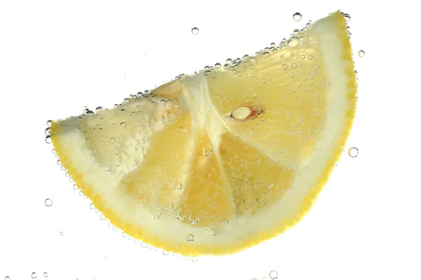 Fetta di limone in acqua con bollicine, isolata su bianco — Foto Stock