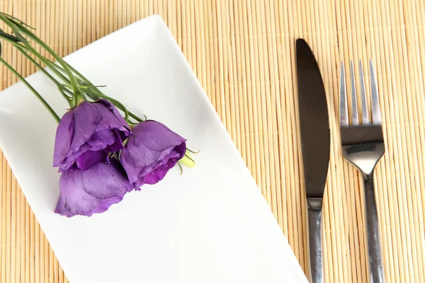 餐具与朵花的竹凉席特写 — 图库照片