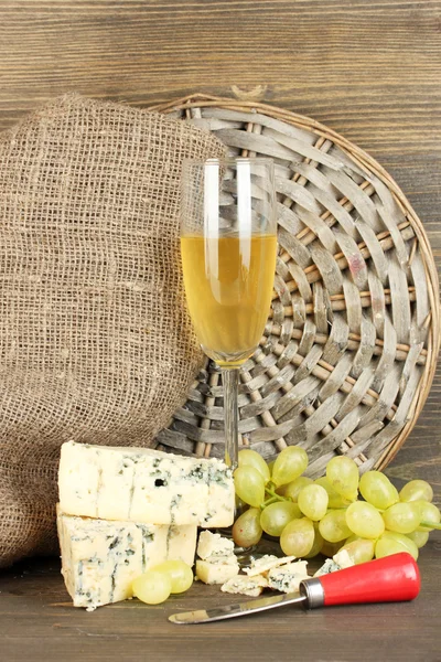 Komposition aus Blauschimmelkäse und einem Glas Wein mit Trauben auf Holzbackgr — Stockfoto