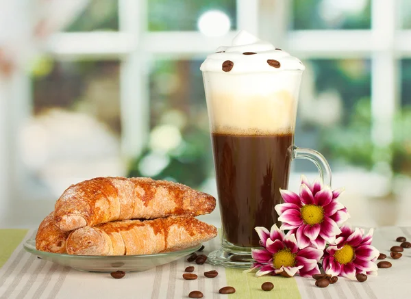 Kieliszek świeżo parzona kawa koktajl i talerzyk z bajgle na stole — Zdjęcie stockowe