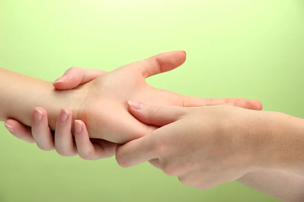 Hand massage, on green background — Stock Photo, Image