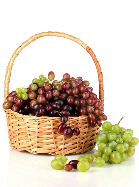 Вкусный спелый розовый и зеленый виноград в корзине изолированы на белом — стоковое фото