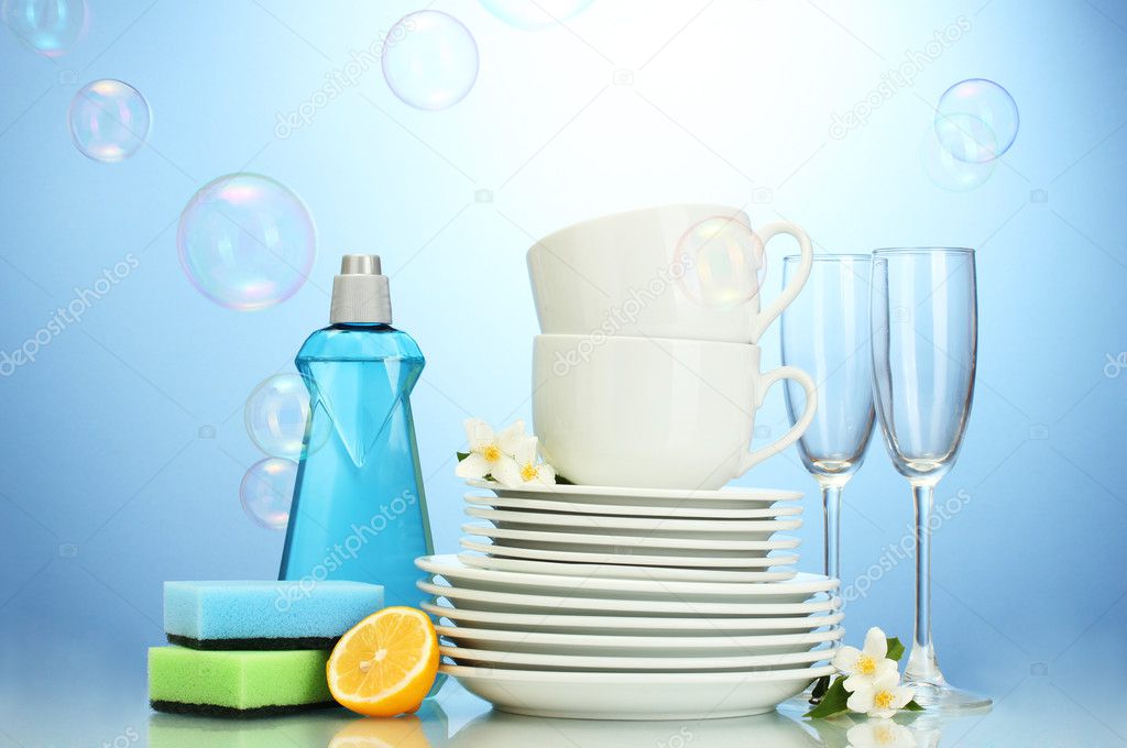 empty clean plates, glasses and cups with dishwashing liquid, sponges and l