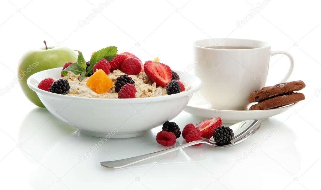 tasty oatmeal with berries and cup of tea, isolated on white