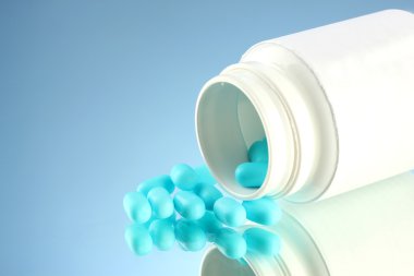 şişe mavi zemin üzerine kapsül