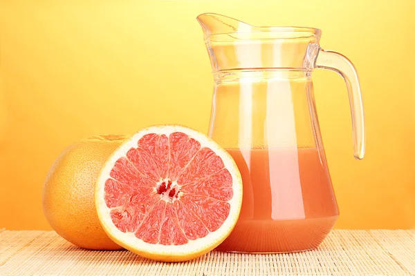Grapefruit-lé és a grapefruit, bambusz mat a sárga háttér — Stock Fotó
