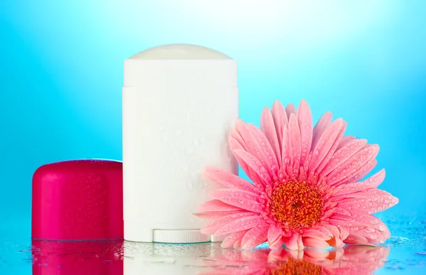 Deodorant with flower on blue background — Stock Photo, Image