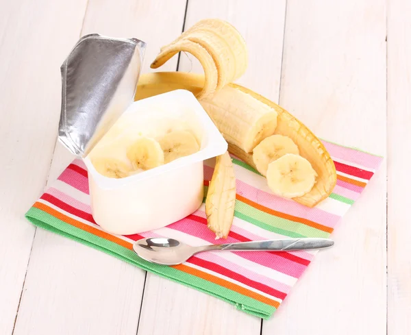 Jogurt s banánem na dřevěné pozadí — Stock fotografie
