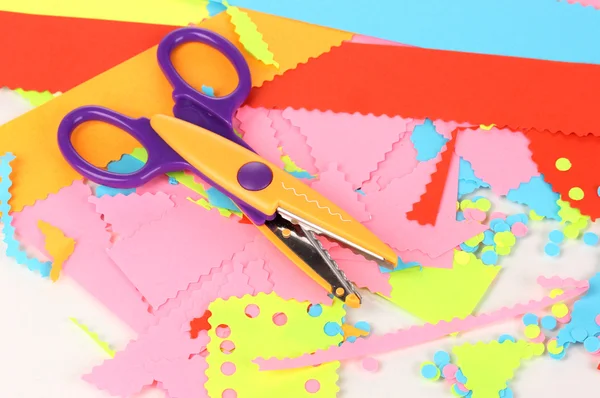 Цветные зигзагообразные ножницы с цветной бумагой, изолированные на белом — стоковое фото