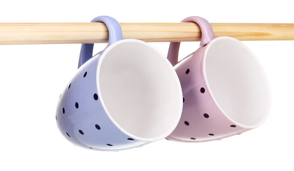 Nice cups hanging on stick isolated on white — Stock Photo, Image