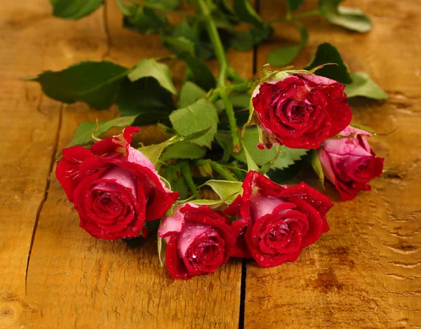 Hermosas rosas vinosas sobre fondo de madera de cerca — Foto de Stock