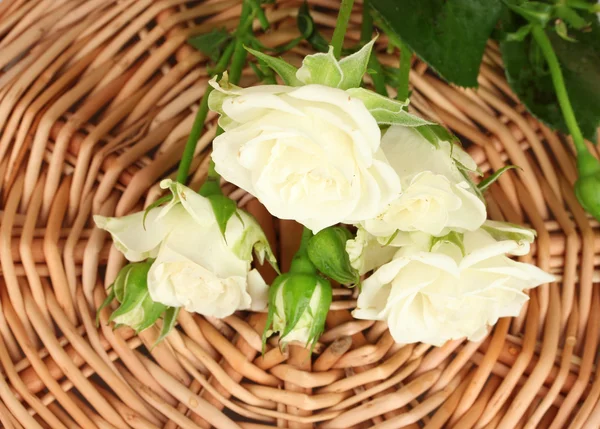 Hermosas rosas blancas en alfombra de mimbre de cerca —  Fotos de Stock