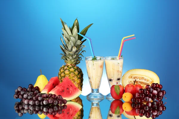 Milk shakes with fruit on blue background close-up — Stock Photo, Image