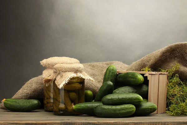 Färska gurkor i trälåda, pickles och dill, på grå bakgrund — Stockfoto