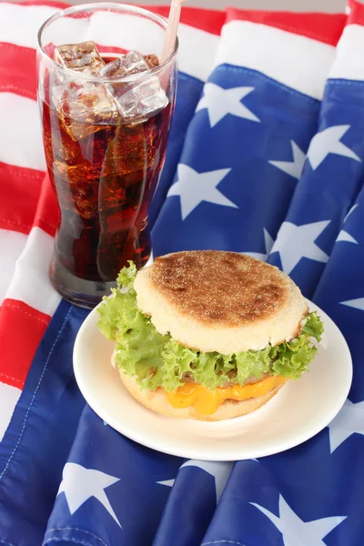 Tasty sandwich and glass with cola, on american flag — Stock Photo, Image