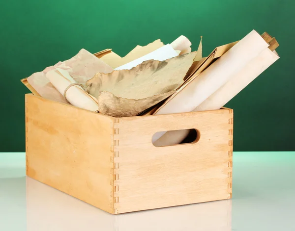 Caisse en bois avec papiers et lettres sur fond vert — Photo