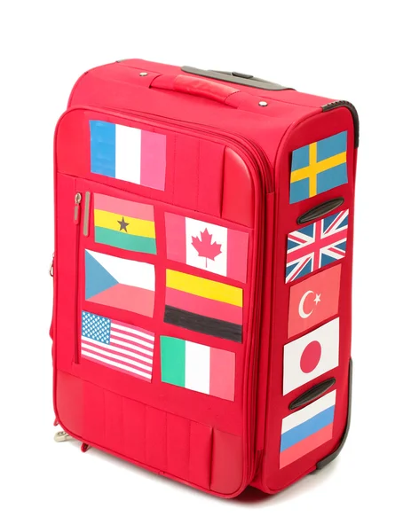 Valise rouge avec de nombreux autocollants avec des drapeaux de différents pays isolés — Photo