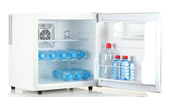 Mini-Kühlschrank voller Mineralwasser isoliert auf weiß — Stockfoto