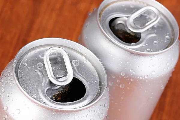 Latas de aluminio con gotas de agua sobre fondo marrón —  Fotos de Stock