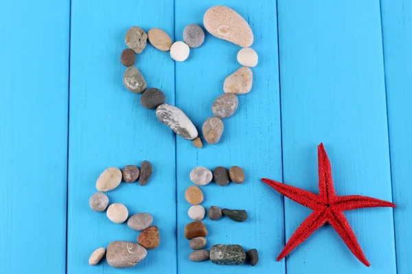 Das Wort Meer und Dekor von Muscheln in Nahaufnahme auf blauem Holztisch — Stockfoto