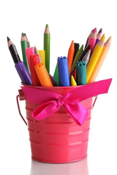 Красочные карандаши и фломастеры в розовом ведре, изолированные на белом — стоковое фото