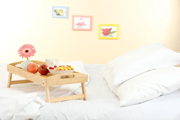 Wooden tray with light breakfast on bed — Stock Photo, Image