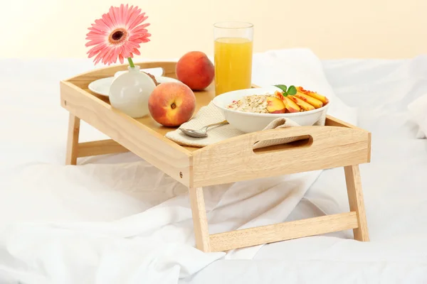 Wooden tray with light breakfast on bed — Stock Photo, Image