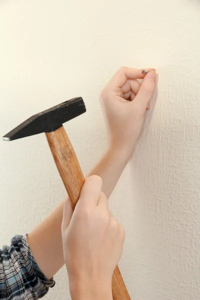 Vrouw handen met nagel en de hamer — Stockfoto