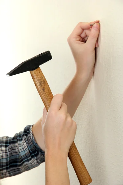 Woman hands with nail and hammer — Stock Photo, Image