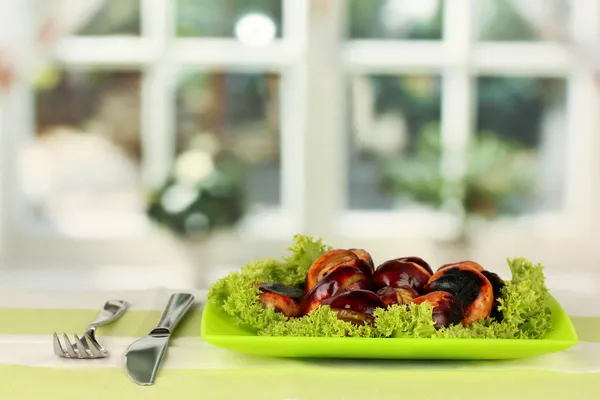 Roasted chestnuts with lettuce in the plate on the tablecloth close-up — Stock Photo, Image