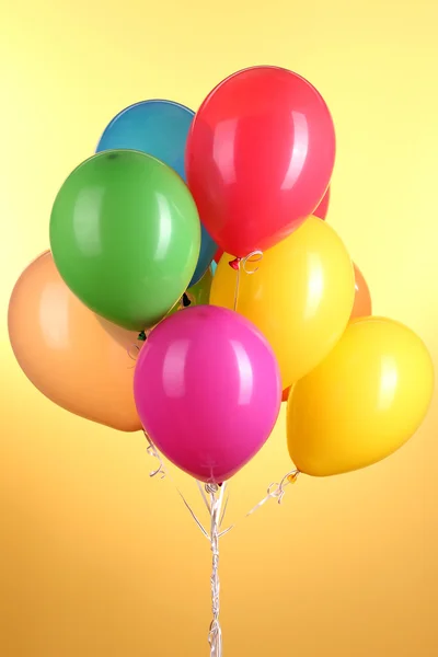 Colorful balloons on yellow background — Stock Photo, Image