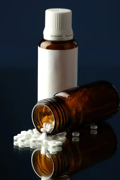 Pills in bottle, on blue background — Stock Photo, Image