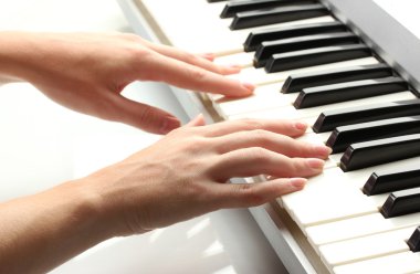 synthesizer oynarken kadının elleri