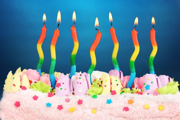 Verjaardagstaart met kaarsen op blauwe achtergrond — Stockfoto
