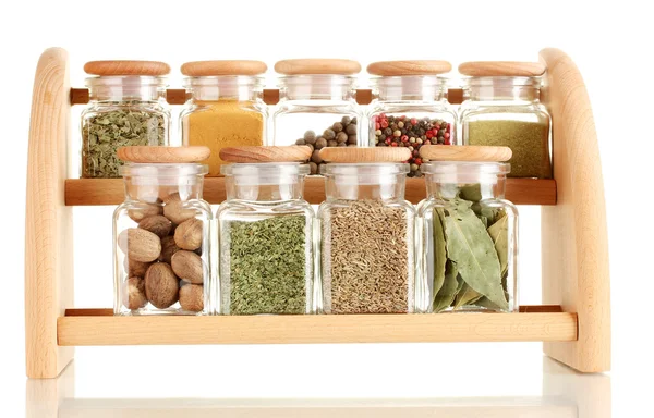 Powder spices in glass jars on wooden shelf isolated on white — Stock Photo, Image