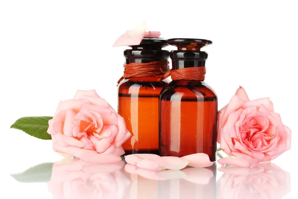 Bottles of oil and roses isolated on white — Stock Photo, Image
