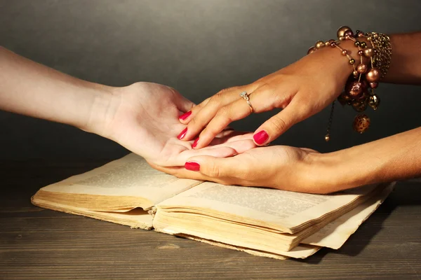 Читання ліній рукою в руках жінки на сірому фоні — стокове фото