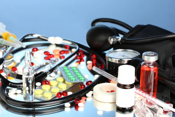 Medicines and a stethoscope on a blue background close-up — Stock Photo, Image