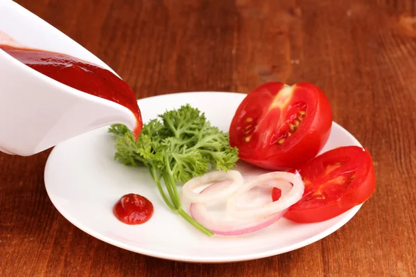 Reife Tomatenscheiben auf Teller auf Holztisch — Stockfoto