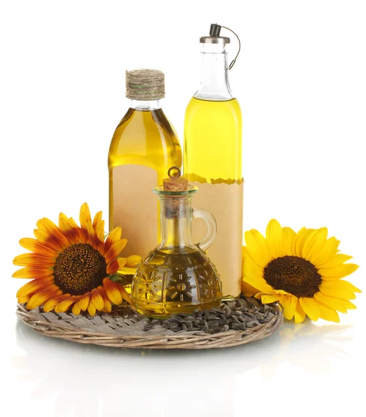 Oil in bottles, sunflowers and seeds isolated on white — Stock Photo, Image