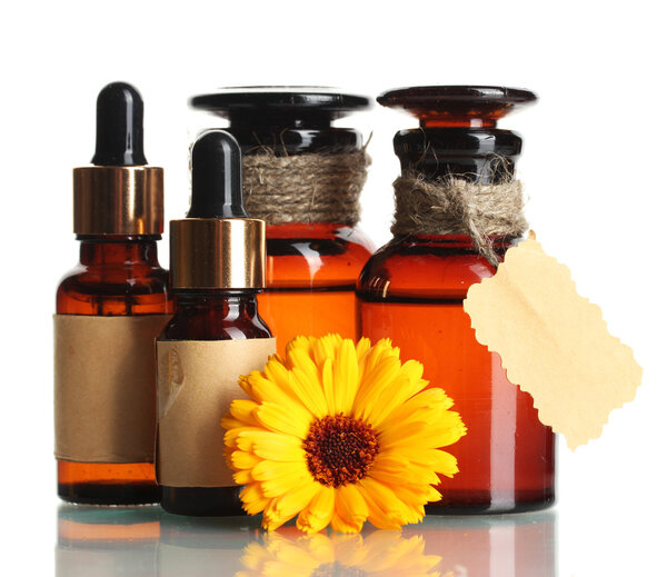 Медицинские бутылки и красивый цветок календулы, изолированные на белом
