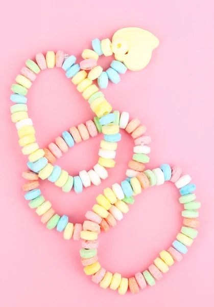 Color candies on rope on pink background — Stock Photo, Image