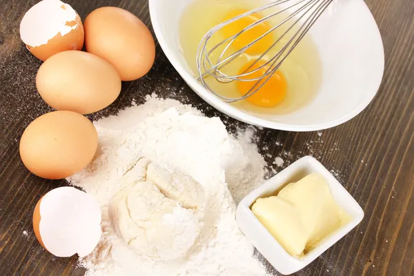 Huevos, harina y mantequilla de cerca en la mesa de madera —  Fotos de Stock