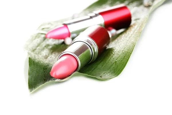 Lipsticks on green leaf isolated on white — Stock Photo, Image