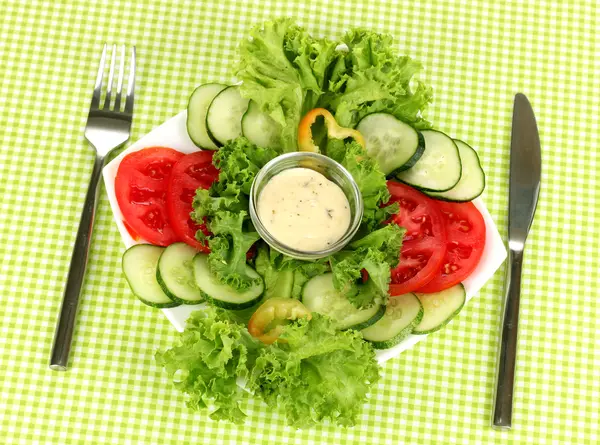 Verduras picadas y salsa en plato sobre mantel verde —  Fotos de Stock