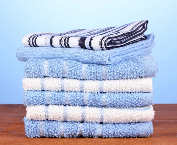 Kitchen towels on wooden table on blue background close-up — Stock Photo, Image