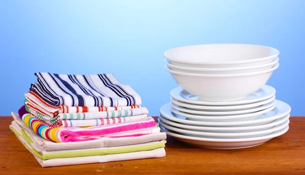 Kitchen towels with dishes on blue background close-up — Stock Photo, Image