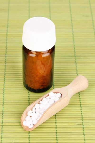Medicine bottle with tablets on bamboo mat — Stock Photo, Image