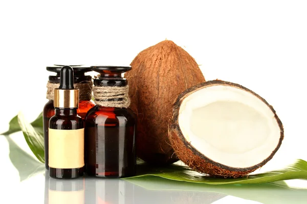 Coconut oil in bottles with coconuts on white background — Stock Photo, Image